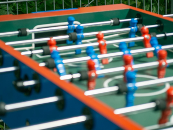 Ein Tischkicker mit roten und blauen Holzspielfiguren.